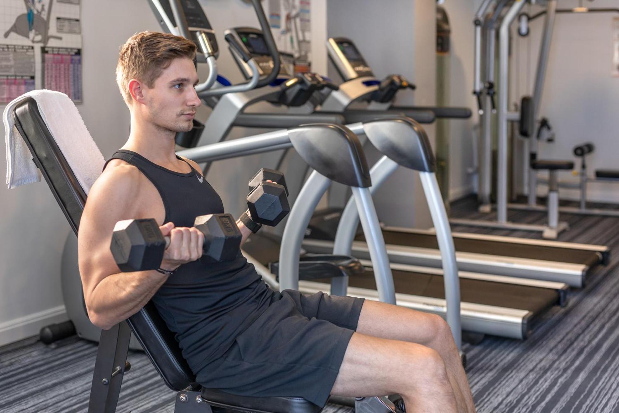 Meriton Suites North Ryde Sydney Exterior photo A man using a dumbbell to exercise